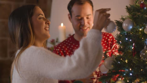 Tracking-Shot-Approaching-Couple-Decorating-Christmas-Tree-Together