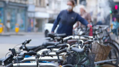 Defocused-Panning-Shot-Revealing-Bicycle-Rack-and-City-Crowd
