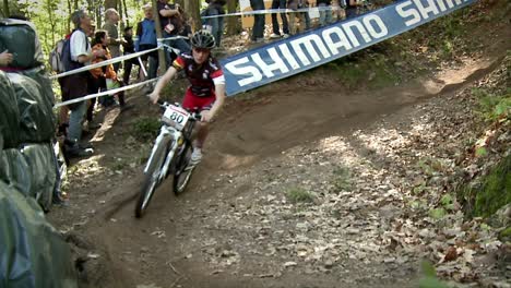 Bicyclists-race-in-the-woods-as-spectators-watch