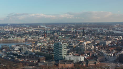 Wide-aerial-view-of-Hamburg-city-center-with-tall-churches-and-landmarks-rising-above-urban-cityscape