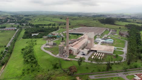 Aerial-view-of-industry-plant-chimney,-industrial-area-in-the-middle-of-green-area,-the-glass-production