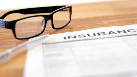 Close-up-of-insurance-contract,-pen-and-spectacle