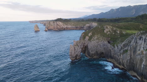 Aerial-View-Of-Sea-Waves-Breaking-On-Rocky-Coastline