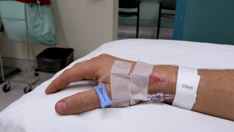 Slow-moving-hand-movements-of-unrecognizable-Caucasian-male-right-hand-in-medical-scenario-with-IV-in-wrist