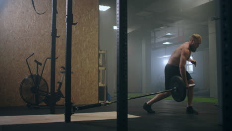Slow-motion:-Man-doing-Single-Arm-Landmine-Squat-to-Press-exercise.-Young-man-lifting-barbell-with-light-weights-at-gym