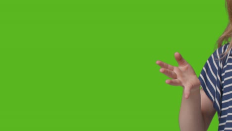 Close-Up-Of-Young-Girl-Waving-To-Camera-Against-Green-Screen